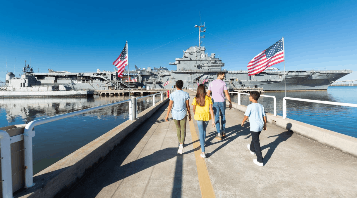 Family walking along the pier toward the USS Yorktown aircraft carrier at Patriots Point 
