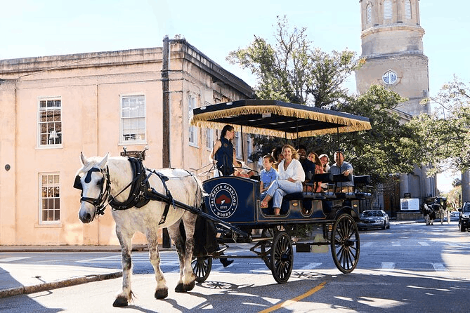A white horse pulling a Palmetto Carriage Works tour carriage filled with tourists on a historic street in Charleston.