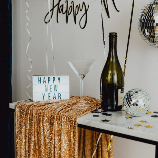 A festive New Year's Eve setup featuring champagne, disco balls, and celebratory decor. A festive New Year's Eve setup featuring champagne, disco balls, and celebratory decor.