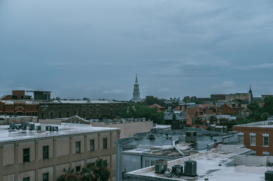 Aerial cityscape of Downtown Charleston, SC showcasing historic architecture under a cloudy sky.