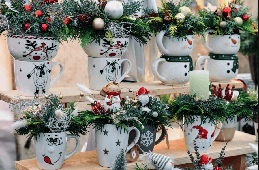Christmas-themed mugs decorated with evergreen branches and ornaments.