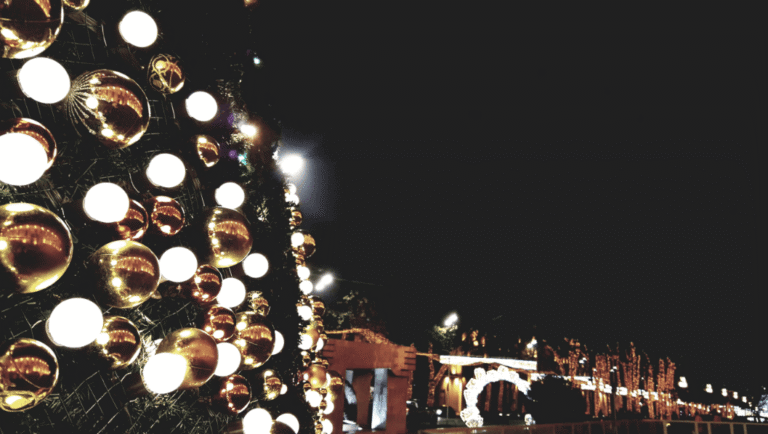 Festive Christmas decorations glowing at night in an urban environment, creating a joyful atmosphere.