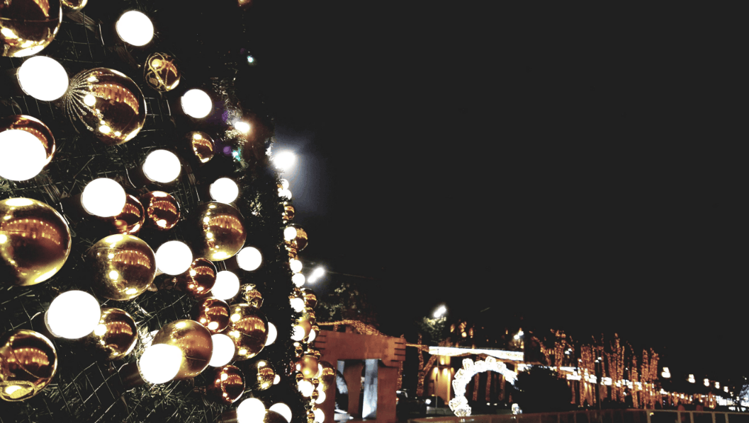 Festive Christmas decorations glowing at night in an urban environment, creating a joyful atmosphere.